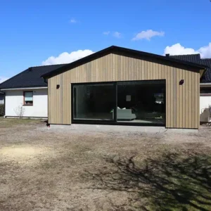 Exteriör på ett färdigställt utbygge på en vit villa. Byggtjänst i Träslöv AB är en byggfirma som hjälper dig med professionell om- och tillbyggnad i Varberg.