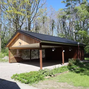 Nybyggd rymlig carport i trä med svart tak, uppförd som totalentreprenad av Byggtjänst i Träslöv AB i Varberg.