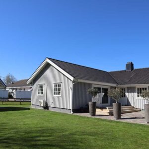 Utvändig bild på en färdigställd tillbyggnad av ett grått trähus med vita fönster. Byggtjänst i Träslöv AB utför om- och tillbyggnad i Varberg.