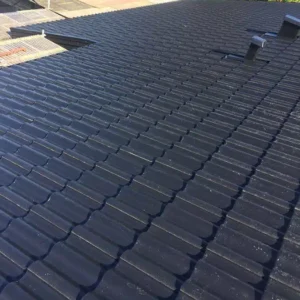Närbild på ett nylagt tak med svarta och hållbara betongpannor.