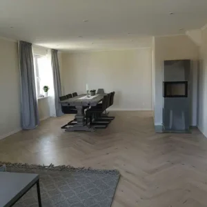 Ljust och rymligt vardagsrum med nylagd fiskbensparkett efter en ytskiktsrenovering i Varberg.